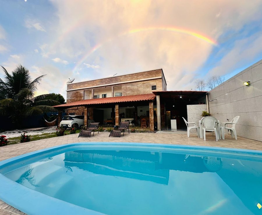 Piscina e prédio da Pousada Costa do Sol ao entardecer
