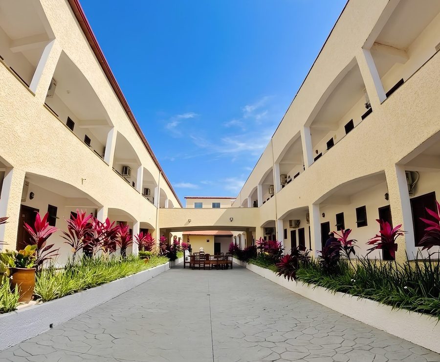 Pátio interno da Pousada Flor do Sol, com floreiras e os apartamentos em volta