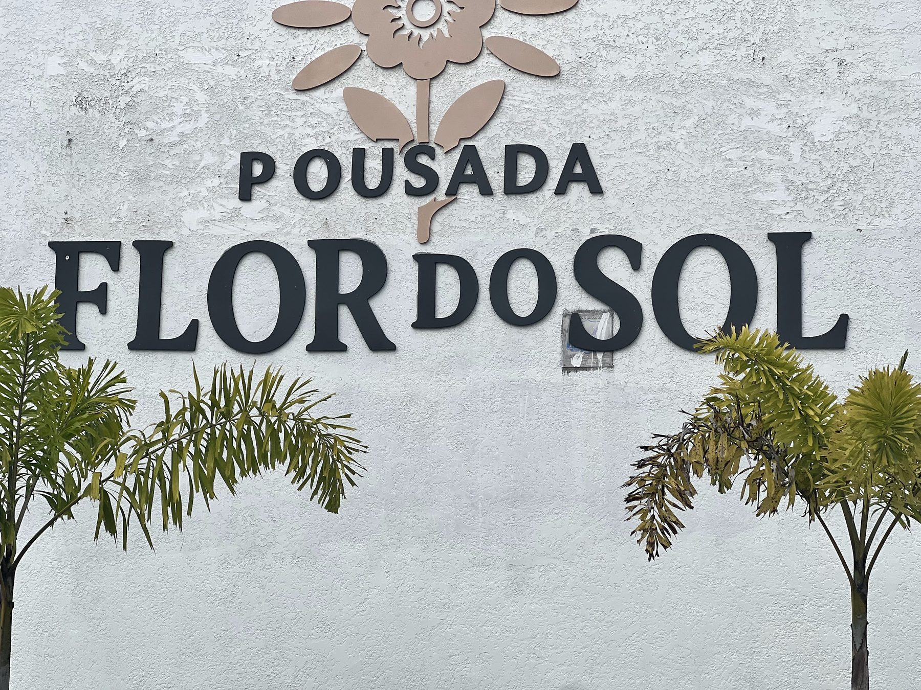 Letreiro Pousada Flor do Sol na parede da fachada
