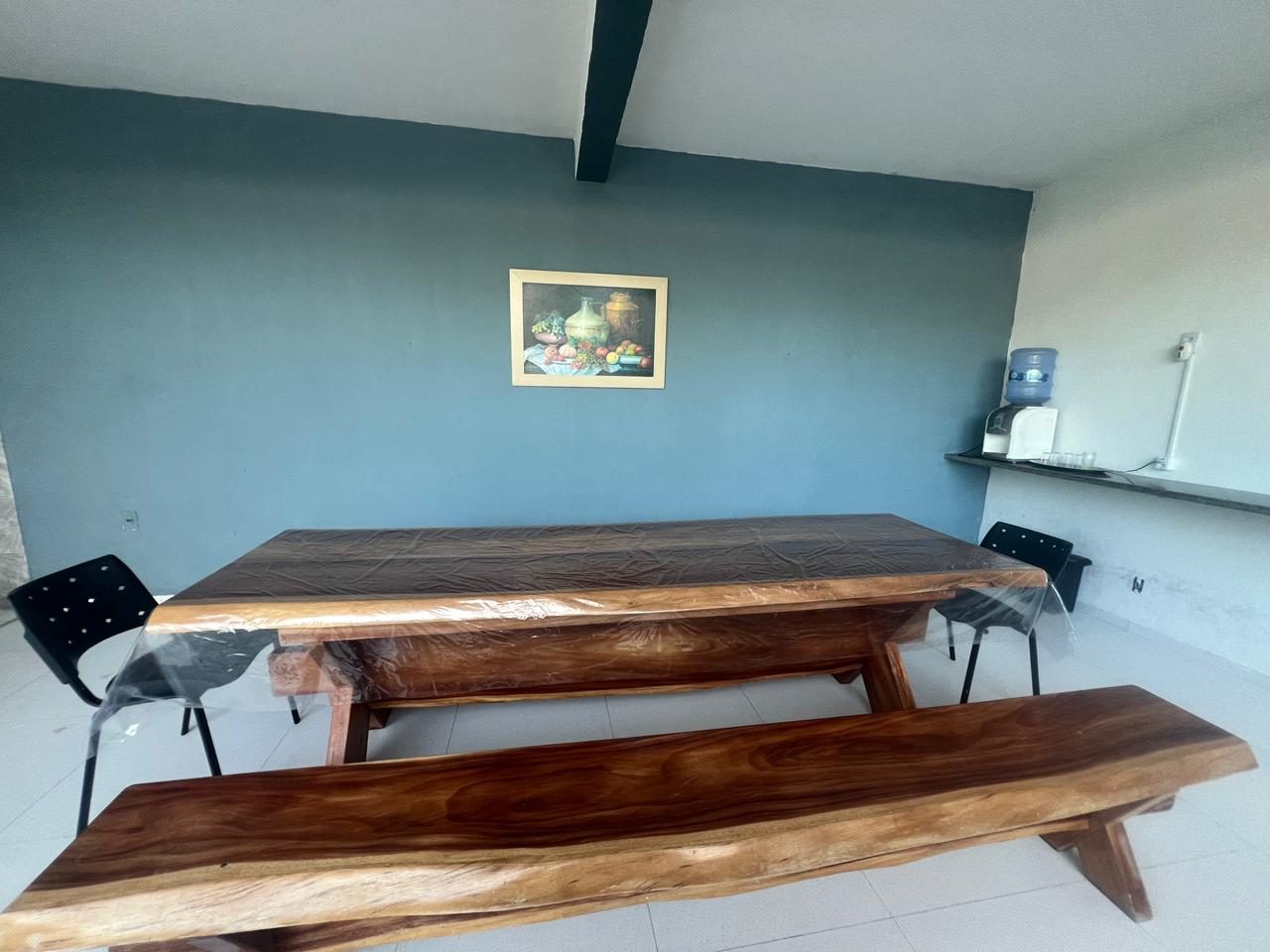 Mesa de madeira rústica na área coberta de refeições