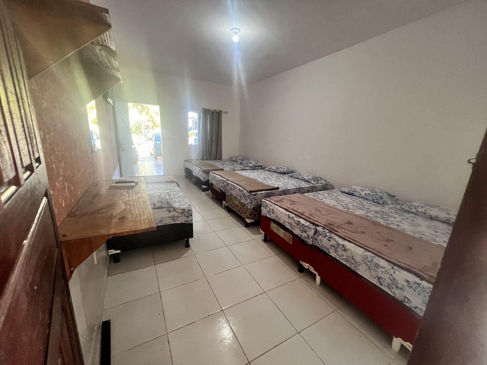 Suíte 13 vista da entrada, com as camas enfileiradas e a janela ao fundo